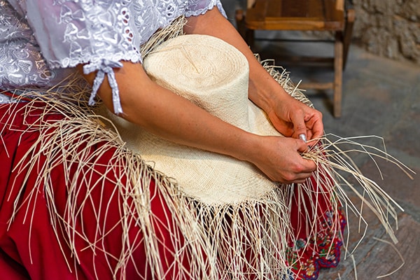 Eine Frau flechtet einen Panamahut aus Toquilla