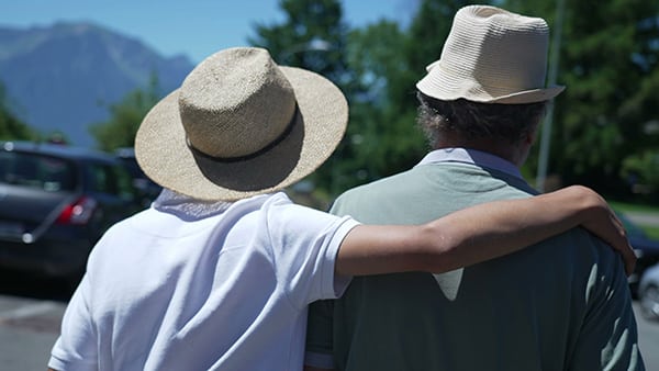 Zwei Männer tragen Panamahüte und spazieren